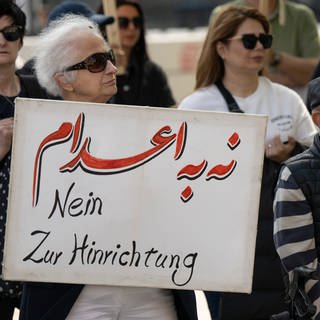Gegen die jüngsten Hinrichtungen im Iran protestieren Exil-Iraner vor der Alten Oper in Frankfurt. Dabei steht auf einem Plakat „Nein zur Hinrichtung“.