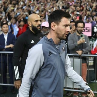 Lionel Messi, Fußballstar aus Argentinien und Kapitän von Inter Miami CF, betritt das Hongkong-Stadion, das von Messi-Fans umringt ist, die seinen Namen bejubeln. 