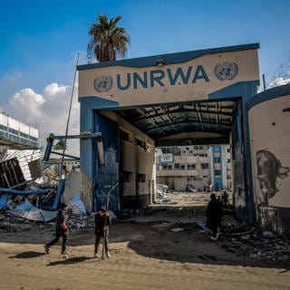 Palästinenser begutachten die Schäden an den Gebäuden des Hilfswerks der Vereinten Nationen für Palästinaflüchtlinge (UNRWA) auf dem Weg zurück in ihre Häuser, nachdem sich die israelische Armee aus dem Norden von Gaza-Stadt zurückgezogen hat.