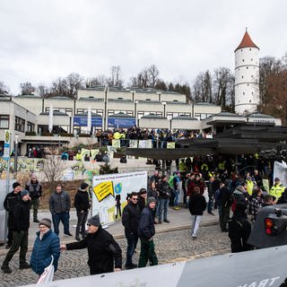 Zahlreiche Menschen versammeln sich beim politischen Aschermittwoch der baden-württembergischen Grünen vor der Stadthalle von Biberach an der Riß, um zu demonstrieren.