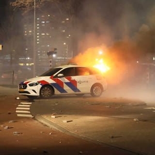 Ein brennendes Polizeiauto vor dem Opernhaus am Fruitweg. Die Polizei greift in eine Konfrontation zwischen zwei Eritreergruppen ein, nachdem es nach einem Treffen im Konferenzzentrum zu Unruhen kam.