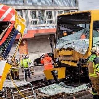 Einsatzkräfte der Feuerwehr arbeiten an zwei zerstörten Stadtbahnen. Bei dem Zusammenstoß zweier Stadtbahnen im Stuttgarter Stadtteil Wangen sind mehrere Menschen verletzt worden.