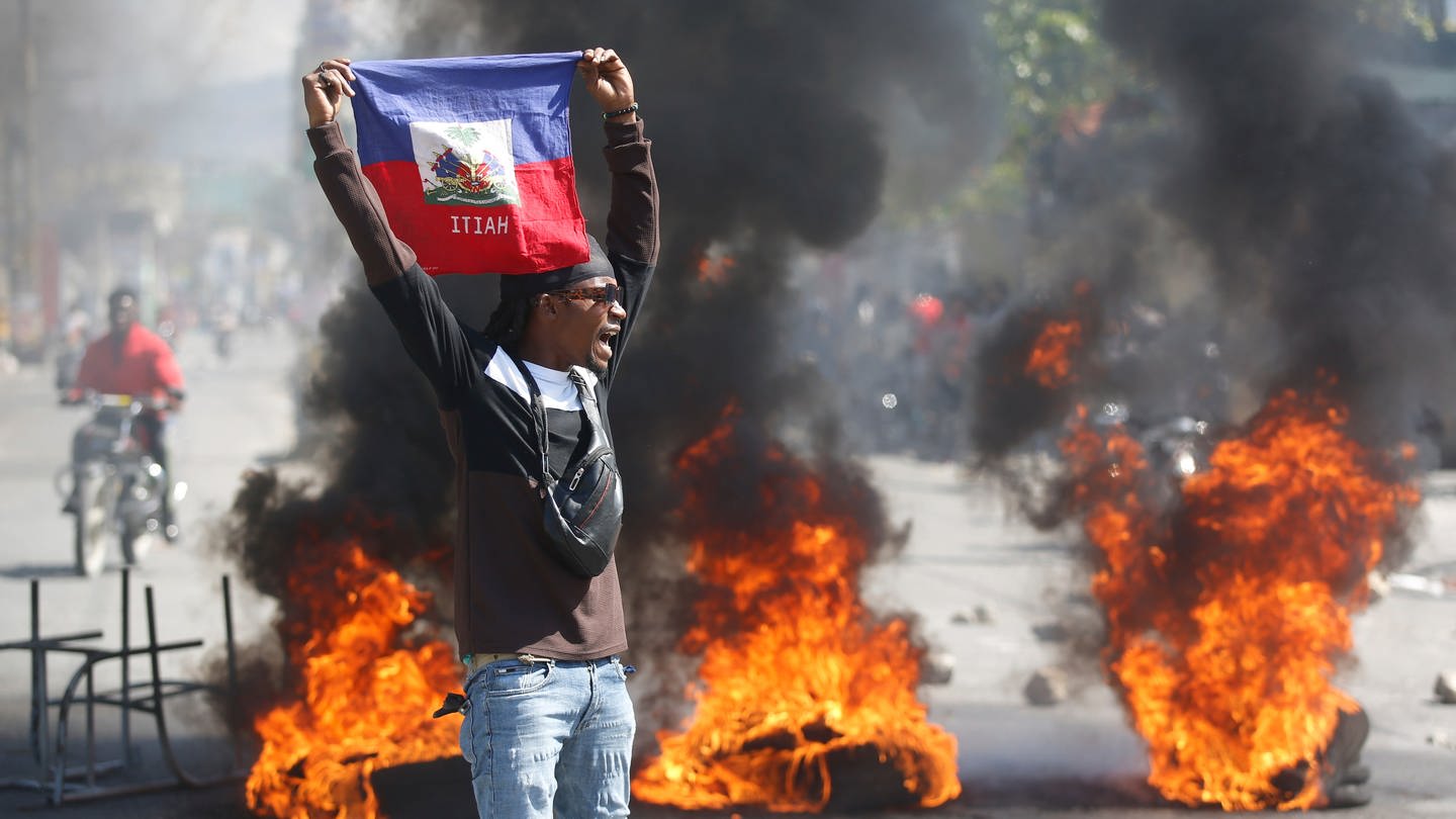 Ein Demonstrant hält eine haitianische Flagge während Protesten für den Rücktritt von Premierminister Henry hoch.