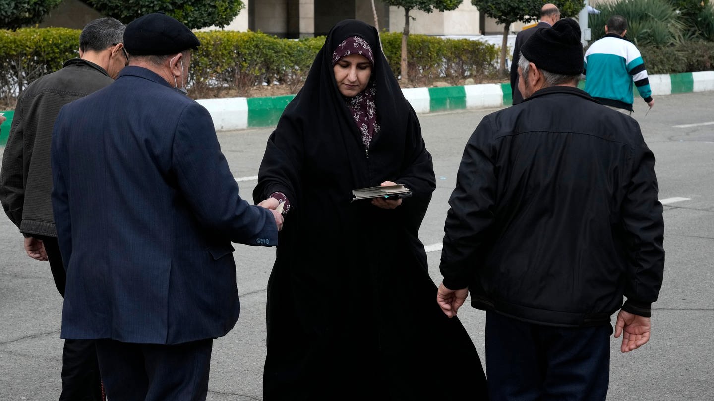 Eine Frau verteilt Wahlprospekte einer Gruppe von Kandidaten für die Wahl des Expertenrates. Am 1. März wählt der Iran ein neues Parlament und den sogenannten Expertenrat. Experten gehen von einer der niedrigsten Wahlbeteiligungen in der Geschichte der Islamischen Republik aus.