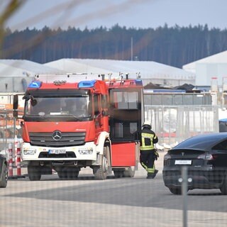 Seit heute Morgen steht die Produktion bei Tesla in Grünheide still. Der Grund? Ein brennender Oberleitungsmast in der Nähe.