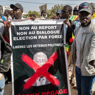 Anhänger des Oppositionskollektivs Aar Sunu Senegal zeigen auf einer Straße in Dakar ein Transparent mit der Aufschrift "Nein zur Verschiebung, nein zum Dialog, Wahl mit Zwang".