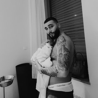 Rapper Samra hält sein erstes Kind auf dem Arm.