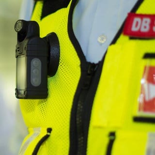 Auf der Weste eines Mitarbeiters der Deutschen Bahn ist eine Bodycam befestigt.