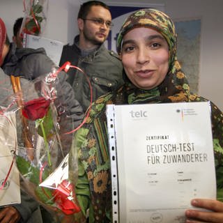Ihre Zertifikate "Deutschtest für Zuwanderer" halten Yussra El Ahmad aus dem Libanon (r) und Fathima Bushra Nhras aus Sri Lanka am Freitag (02.12.2011) im dtz-Bildungszentrum im Stadtteil Neukölln in Berlin in den Händen. Die Integrations-Zertifikate wurden an etwa 20 Menschen für ihre erfolgreich bestandene Deutsch-B1-Prüfung verliehen. 