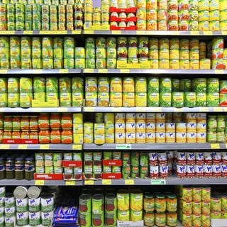 SYMBOLBILD: Lebensmittelabteilung in einem großen Supermarkt mit einem Regal mit Auswahl an Konservendosen.