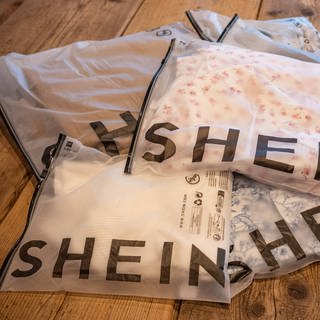 Kleidung vom Fast-Fashion-Unternehmen Shein in gebrandeter Verpackung (Foto: IMAGO, IMAGO / onemorepicture)