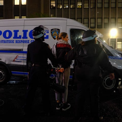 New Yorker Polizeibeamte eskortieren einen Demonstranten vor dem Campus der Columbia University, in New York.