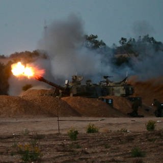 Eine israelische Panzerhaubitze feuert in der Nähe des Kerem Shalom Grenzübergangs im Süden Israels eine Granate auf den Gazastreifen ab.