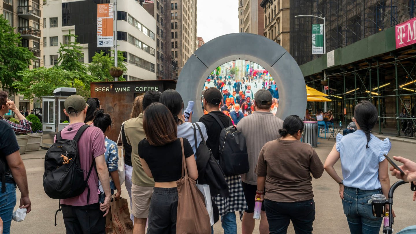 Vor einem Portal in New York stehen mehrere Menschen.