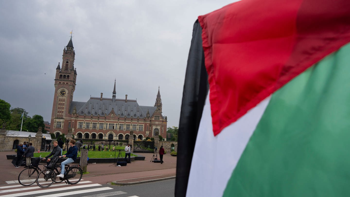 Ein Demonstrant schwenkt die palästinensische Fahne vor dem Friedenspalast, in dem der Internationale Gerichtshof untergebracht ist.