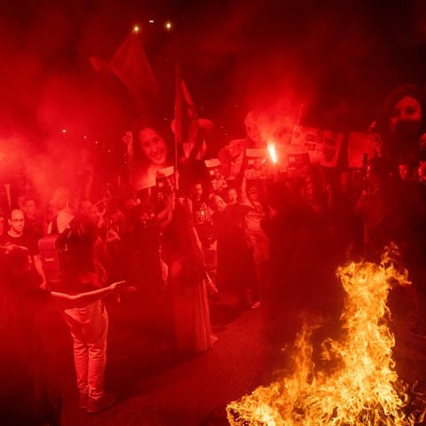Demonstranten halten Schilder und Bilder von Geiseln, die verbrannt werden, während einer Demonstration gegen die Regierung des israelischen Premiers Netanjahu und fordern die Freilassung von Geiseln, die im Gazastreifen von der militanten Hamas-Gruppe festgehalten werden, in Tel Aviv, Israel.