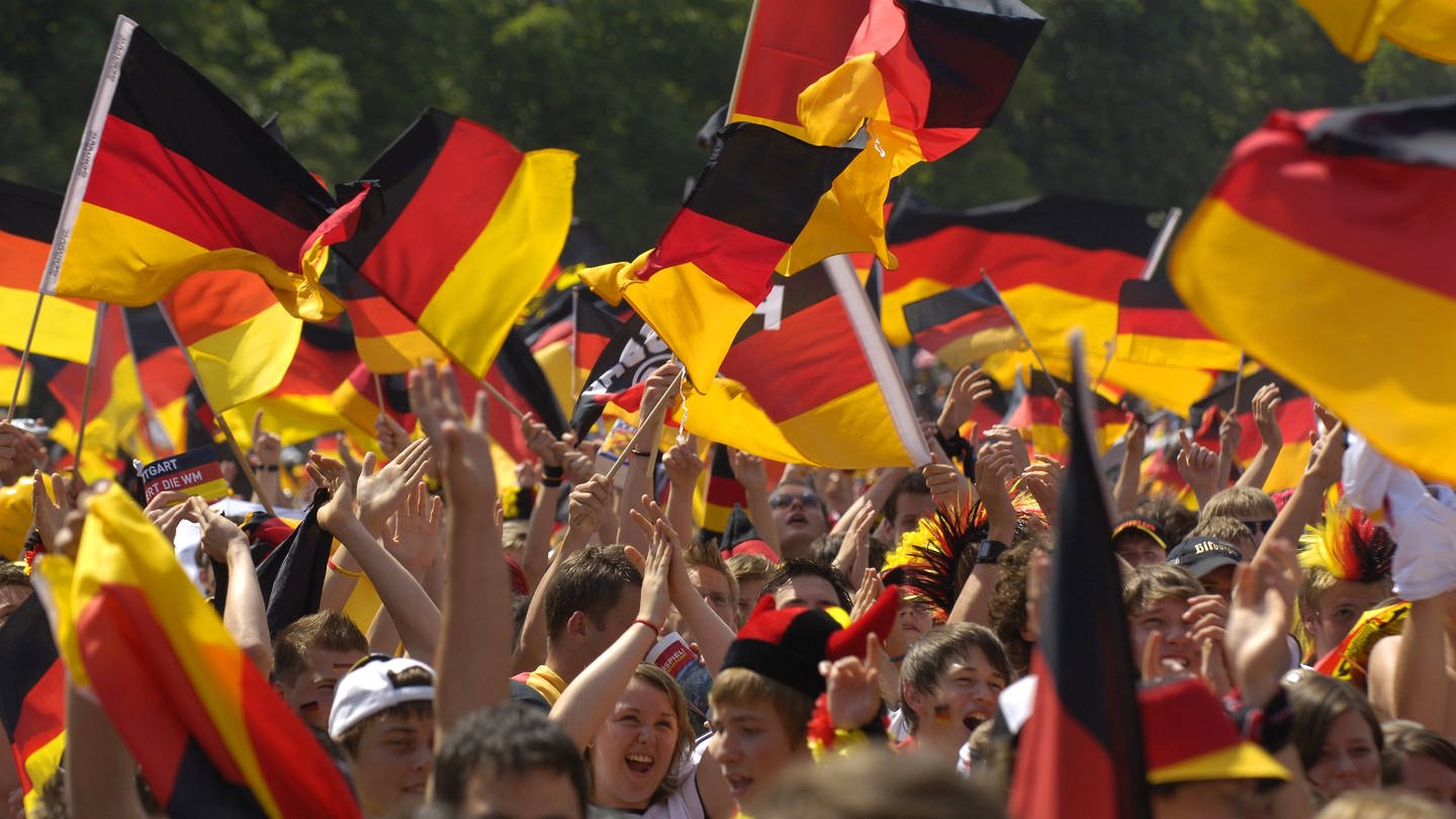 Fans schwenken Deutschlandflaggen auf einem Public Viewing. (Archivbild)