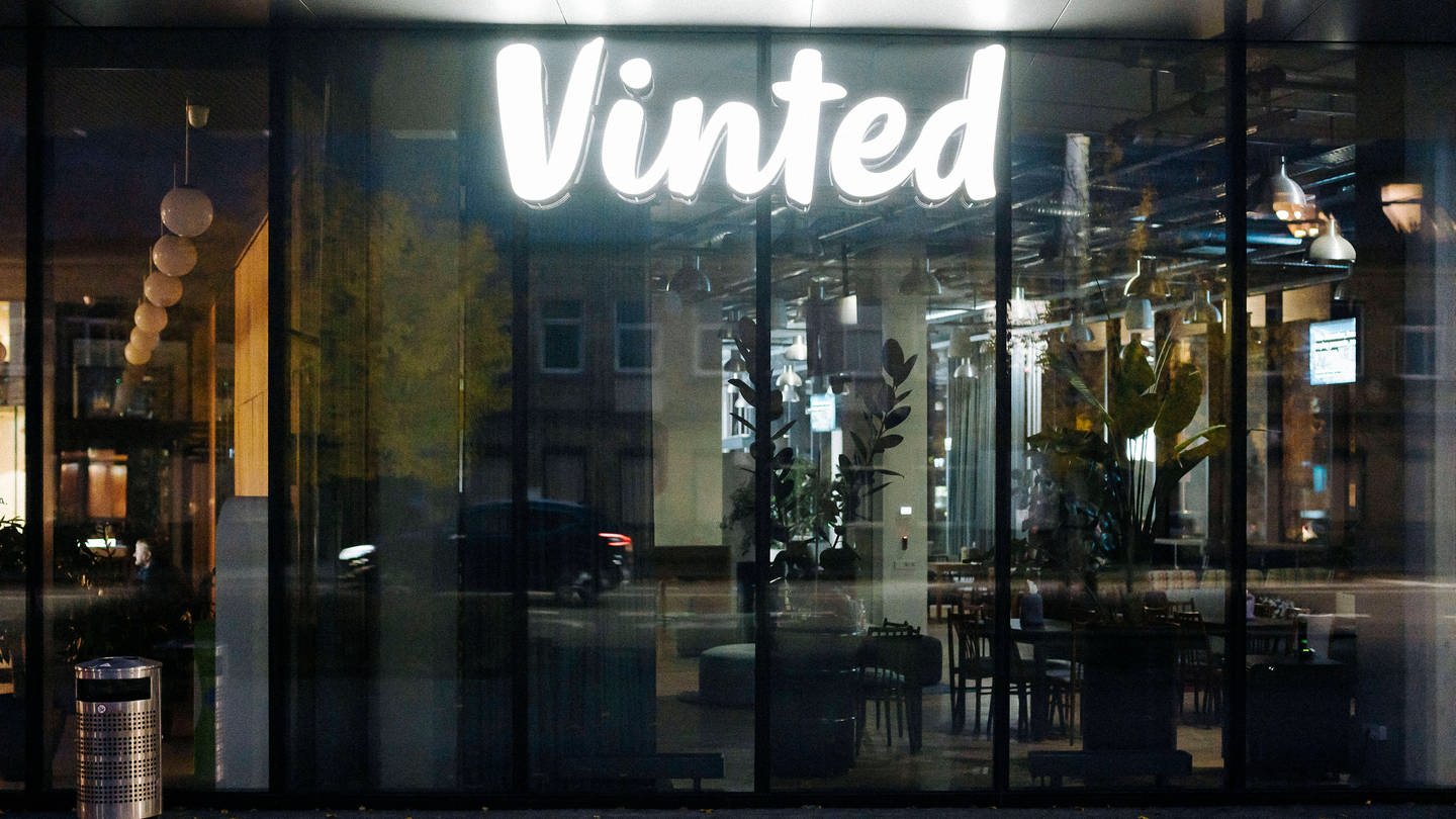 Das Logo von Vinted leuchtet in einem dunklen Bürogebäude.