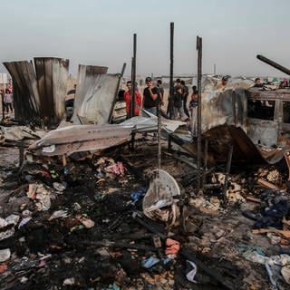 Palästinenser sehen die Zerstörung in einem Flüchtlingslager, das auch bei einem israelischen Angriff auf ein Ziel in Rafah getroffen wurde. 