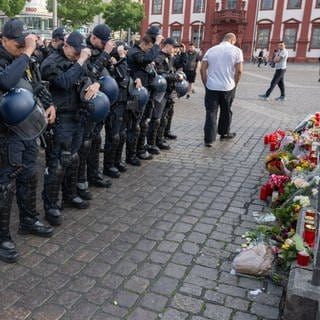Minuten nach dem Bekanntwerden seines Todes trauern Polizisten auf dem Marktplatz in Mannheim um ihren getöteten Kollegen.