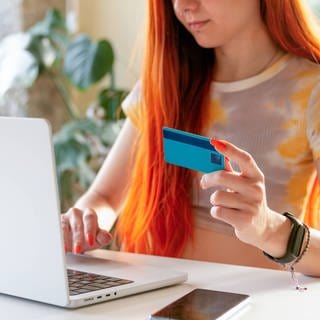 Mädchen mit Kreditkarte am Laptop. Laut Verbraucherschützern gibt es immer mehr Beschwerden wegen Online-Shops. Sie fordern einen besseren Schutz für Kunden.