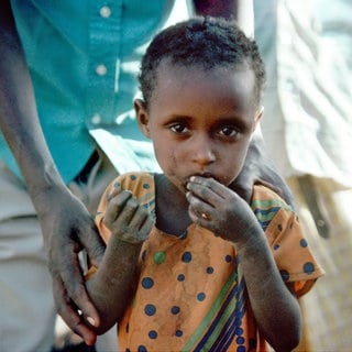 Ein Kind isst in einem Flüchtlingslager im Süden von Somalia. Laut UNICEF leidet jedes vierte Kind weltweit an Ernährungsarmut.