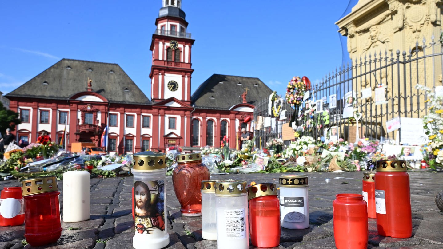 Blumen und Kerzen liegen auf dem Marktplatz in Mannheim zum Gedenken an einen getöteten Polizisten. - Jetzt wird über eine AfD-Demo auf dem Marktplatz diskutiert.