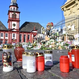 Blumen und Kerzen liegen auf dem Marktplatz in Mannheim zum Gedenken an einen getöteten Polizisten. - Jetzt wird über eine AfD-Demo auf dem Marktplatz diskutiert.