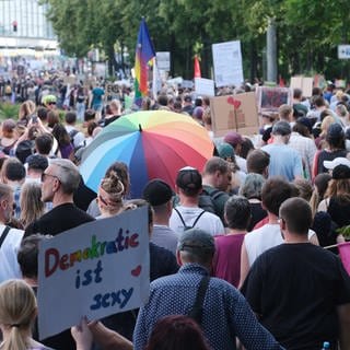 Teilnehmer einer Demonstration mit dem Motto „Hand in Hand für Demokratie und Menschenrechte“ gehen eine Straße entlang. Mehrere tausend Menschen demonstrierten vor der Europawahl gegen antidemokratische Kräfte.