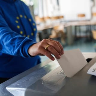 Eine Frau mit Europa-Hoodie wirft ihren Stimmzettel in die Urne. In Deutschland findet heute die Europawahl statt. Deutsche Staatsangehörige sowie Unionsbürger können ihre Stimme abgeben, sofern sie mindestens 16 Jahre alt und an ihrem Wohnort ins Wählerverzeichnis eingetragen sind.