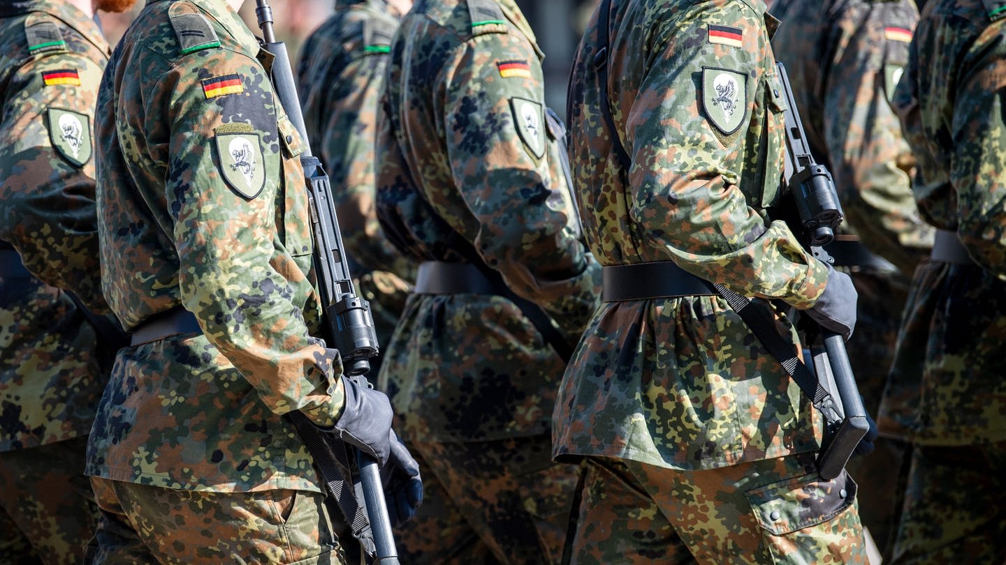 Soldaten der Bundeswehr laufen mit einer Waffe. Pistorius plant einen neuen Wehrdienst.
