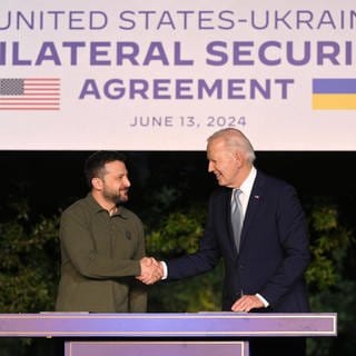 US-Präsident Joe Biden (R) und der ukrainische Präsident Volodymyr Zelensky (L) schütteln sich die Hände nach der Unterzeichnung eines bilateralen Sicherheitsabkommens am Rande des G7-Gipfels in Italien.