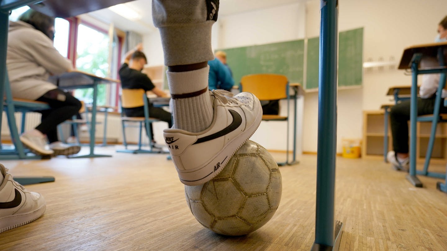 Schülerinnen und Schüler mit Fußball