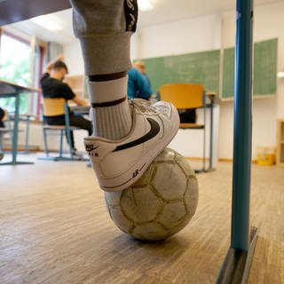 Schülerinnen und Schüler mit Fußball