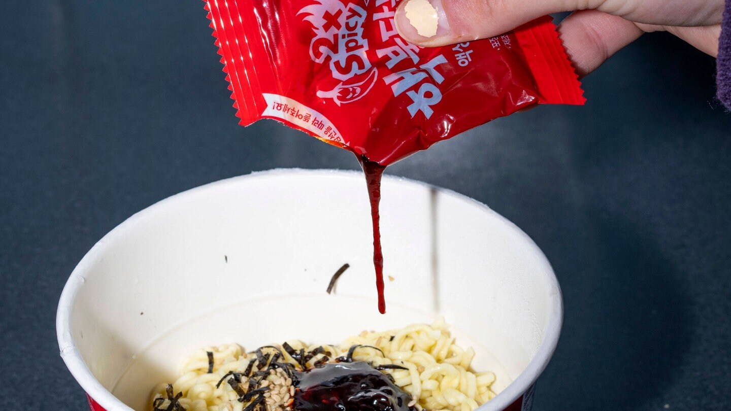 Eine Portion Instant-Ramen von Buldak wird mit der scharfen Soße gewürzt