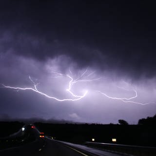 Blitze sind am Nachthimmel zu sehen. In Rheinland-Pfalz warnt der DWD vor Unwetter.