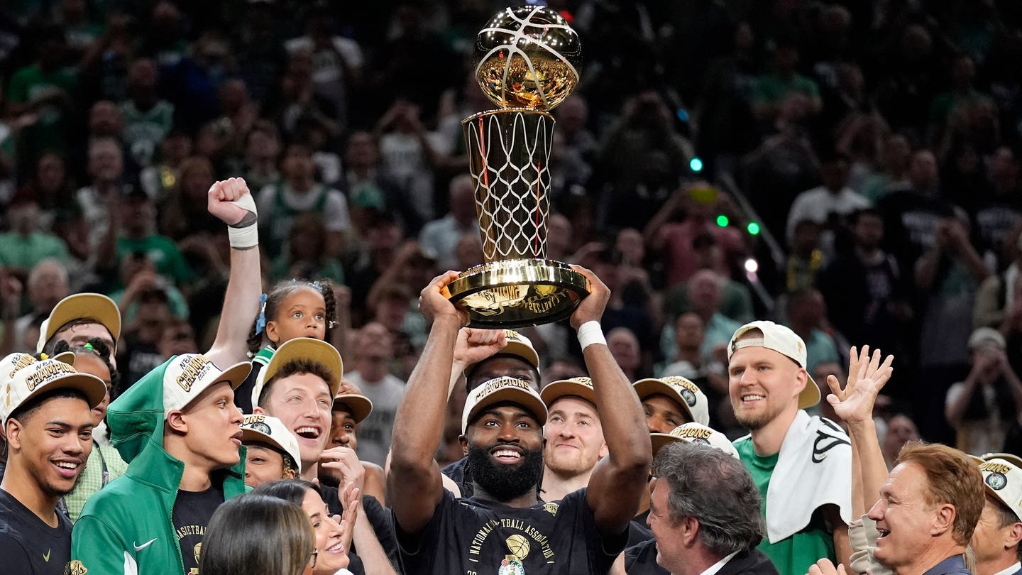 Boston Celtics Guard Jaylen Brown (M) hält die Larry O'Brien Championship Trophy hoch.