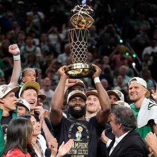 Boston Celtics Guard Jaylen Brown (M) hält die Larry O'Brien Championship Trophy hoch.