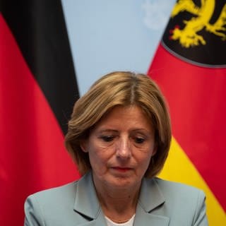 Malu Dreyer (SPD), Ministerpräsidentin von Rheinland-Pfalz, sitzt nach einem Flüchtlingsgipfel der Landesregierung Rheinland-Pfalz mit den Kommunalen Spitzenverbänden in der Staatskanzlei unter den Fahnen der Bundesrepublik (l) und des Landes Rheinland-Pfalz (r).