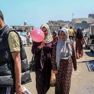 Geflüchtete Palästinenser sind auf einer Straße unterwegs. 