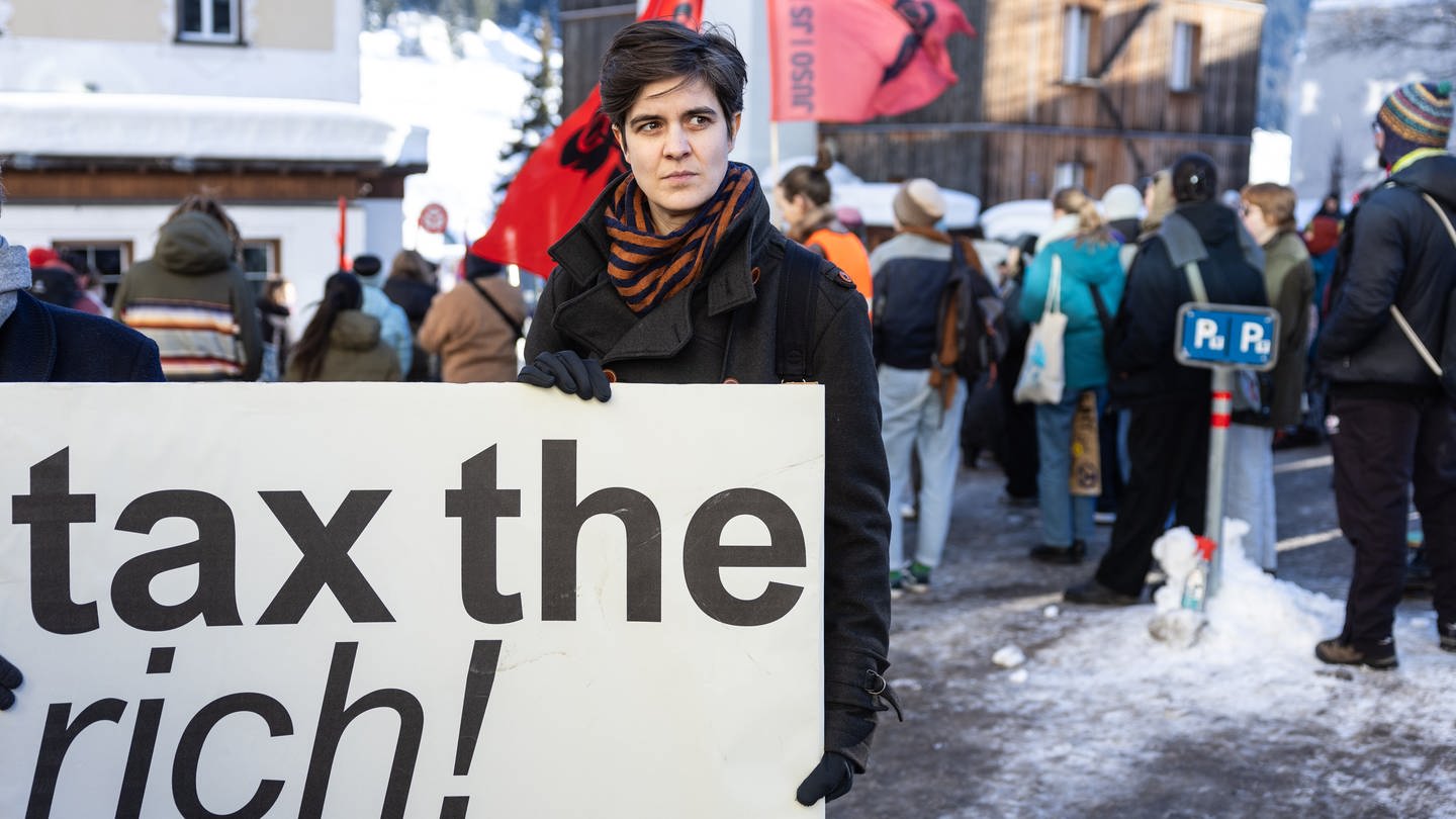 Die deutsch-österreichische Millionenerbin und Sozial-Aktivistin, Marlene Engelhorn hält ein Schild mit der Aufschrift „tax the rich!“ während einer Kundgebung.