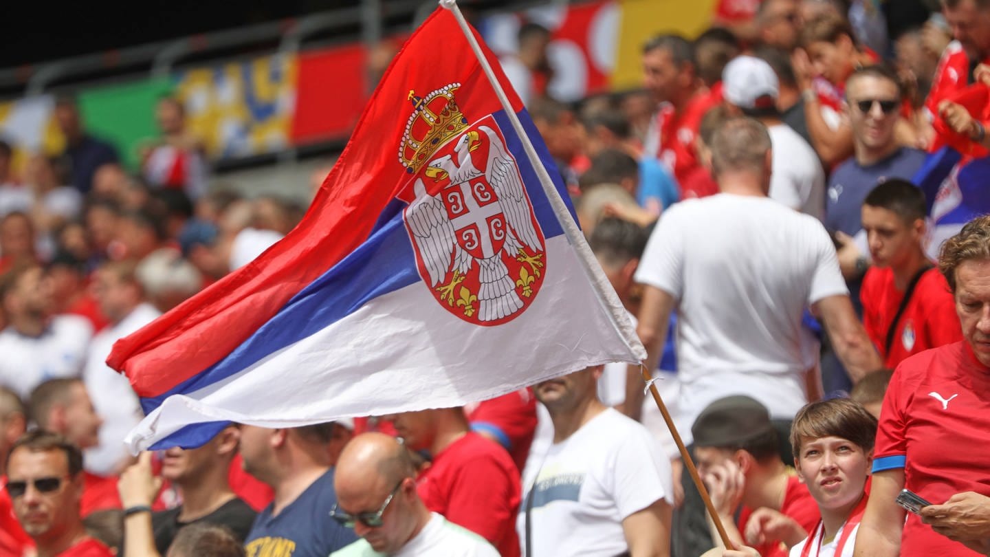 Serbische Fans mit Flagge beim Spiel gegen Slowenien