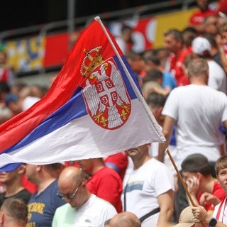 Serbische Fans mit Flagge beim Spiel gegen Slowenien