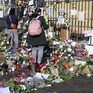 Blumen und Kerzen liegen auf dem Marktplatz in Mannheim zum Gedenken an einen getöteten Polizisten Rouven Laur.