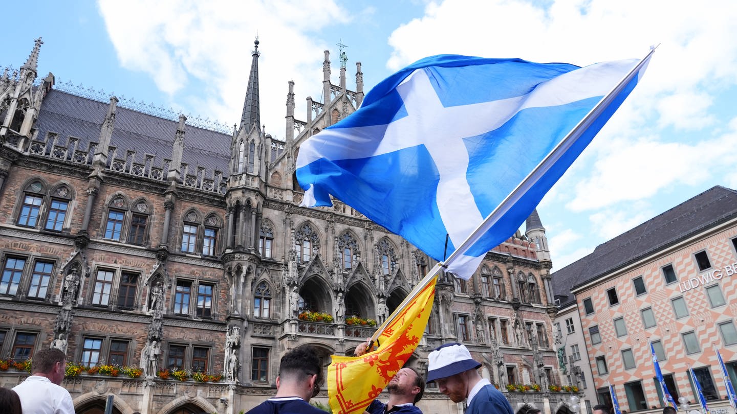 Schottische Fans schwenken die schottische Fahne auf dem Marienplatz.