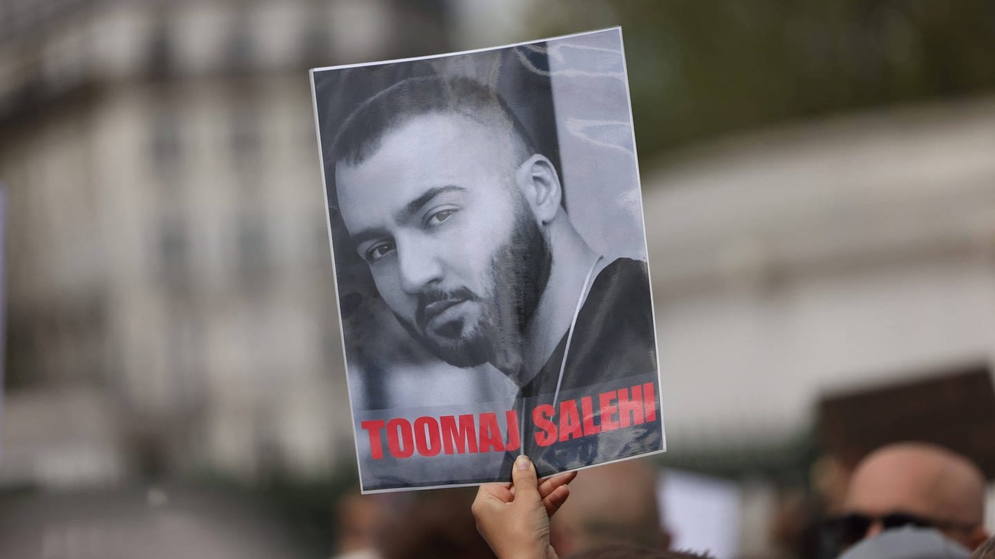 Bei Protesten wird ein Bild des Rappers Toomaj Salehi hochgehalten.