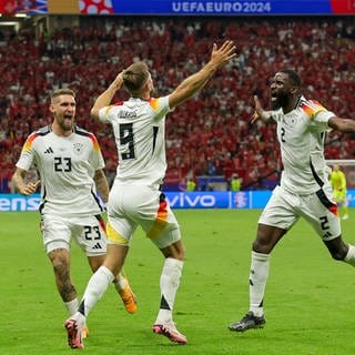 Deutschlands Spieler Robert Andrich (l-r), Niclas Füllkrug und Antonio Rüdiger jubeln nach dem 1:1 gegen die Schweiz bei der Fußball-EM