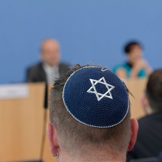 Ein Mann trägt bei der Bundespressekonferenz zum Thema Antisemitische Allianzen eine Kippa.