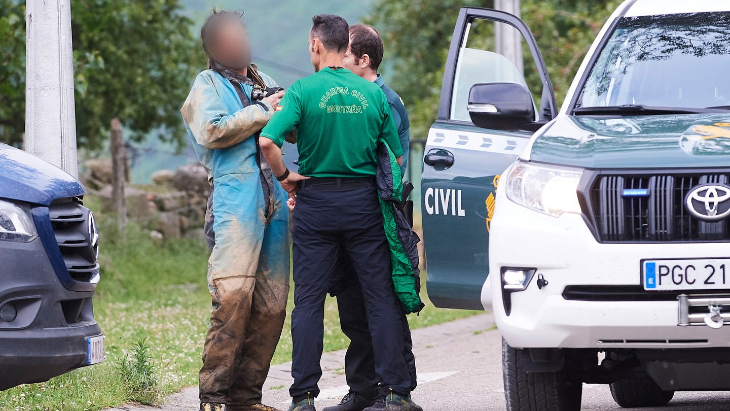 Ein seit Sonntag in Spanien vermisster und geretteter Höhlenforscher (l) spricht mit Rettungskräften. Ihm und der vermissten Forscherin gehe es gut.