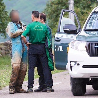 Ein seit Sonntag in Spanien vermisster und geretteter Höhlenforscher (l) spricht mit Rettungskräften. Ihm und der vermissten Forscherin gehe es gut. 